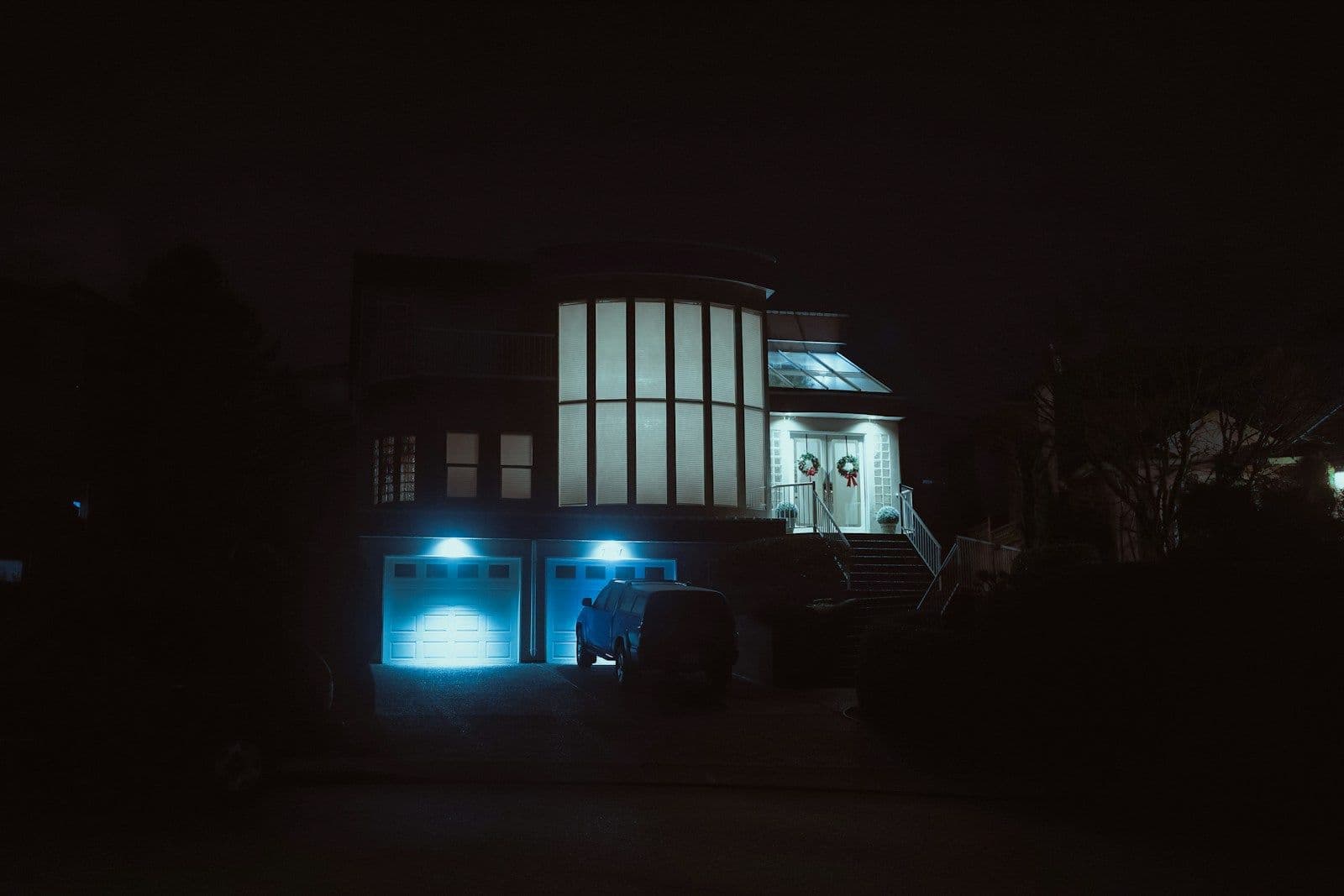 Modern house with blue lights illuminated at night, representing nighttime electricity usage in free nights plans